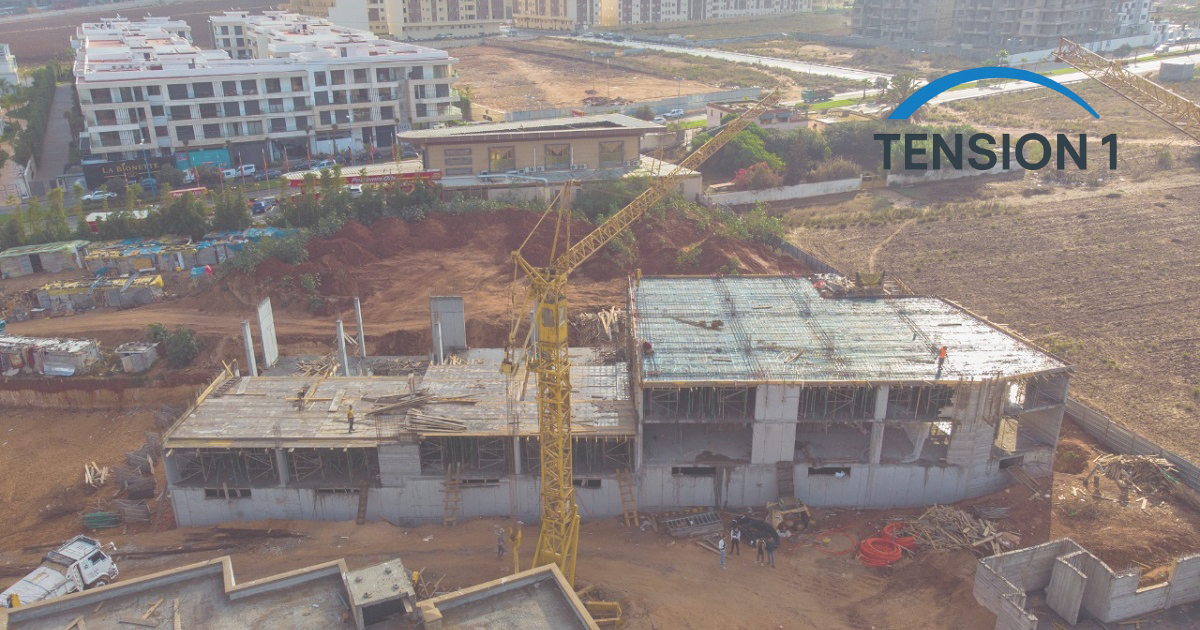 An aerial drone shot of a multi-story building construction site using post tension slabs to reduce concrete volume and environmental impact.
